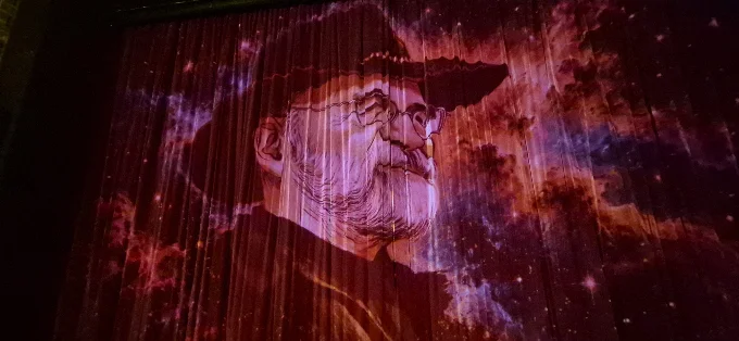 Terry Pratchett projected on curtains
