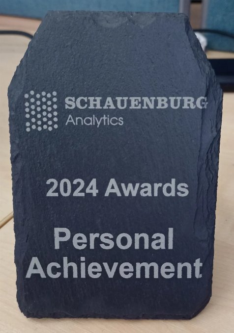 Jason's Work Award Photo of a rectangular piece of Welsh slate with the words Schauenburg Analytics 2024 Awards Personal Achievement
